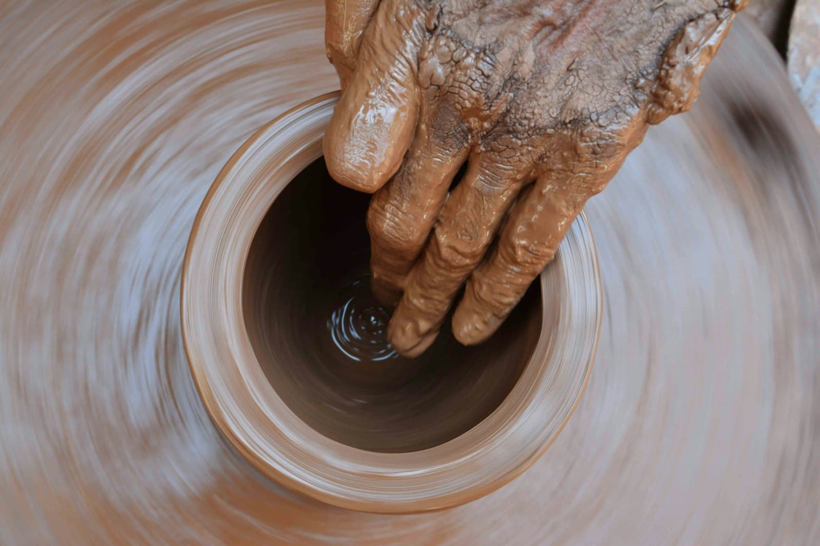 Wet clay spinning on a wheel, close up