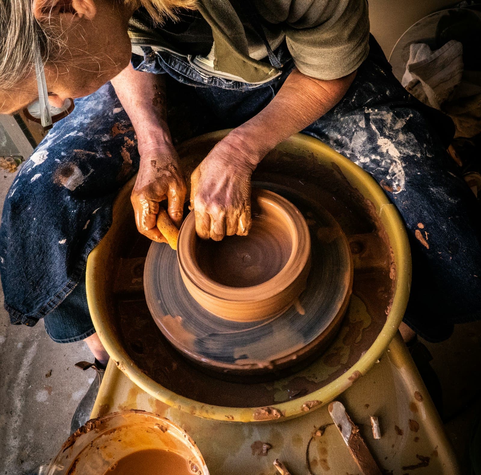 A potter centring clay on a wheel